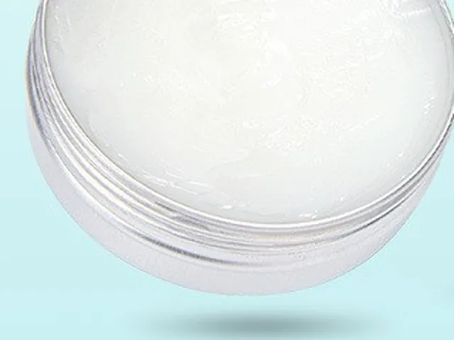 Close-up of an open round metal tin filled with white paw balm